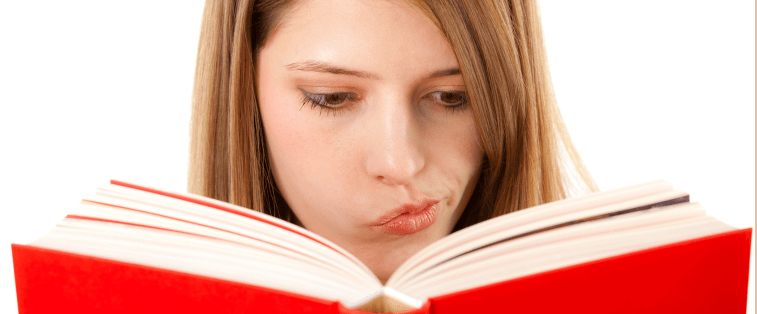 Jeune femme lisant un livre rouge avec un air sceptique, symbolisant le dilemme des lecteurs et lectrices qui n’arrivent pas à abandonner un roman malgré un manque d’intérêt.